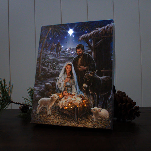 A Savior is Born" 8x6 lighted tabletop canvas depicting nativity scene with Mary, Joseph, baby Jesus, animals, and glowing star.