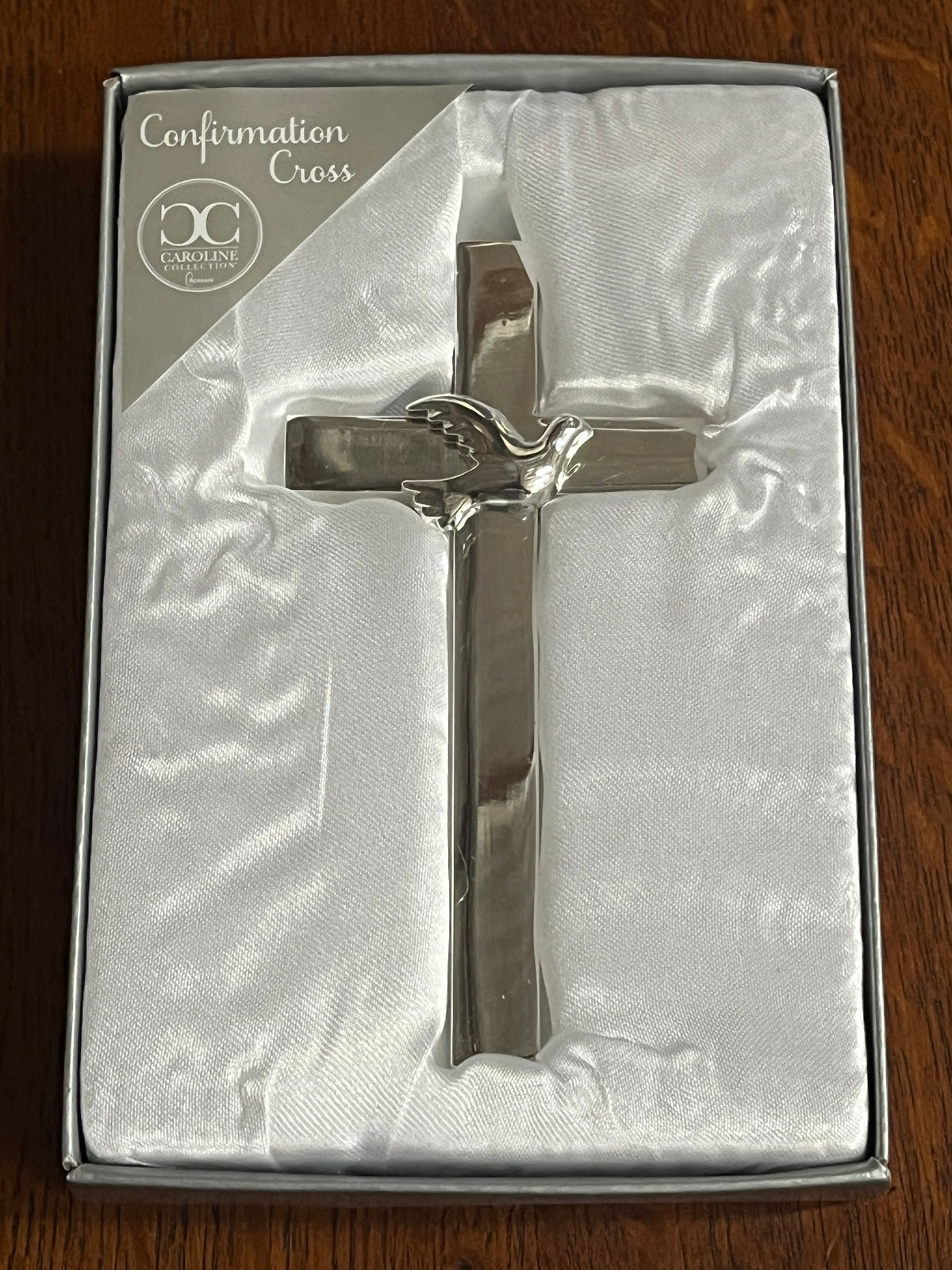 Silver Holy Spirit Confirmation Cross with dove detail, 4.75 inches tall, displayed on white satin fabric in gift box