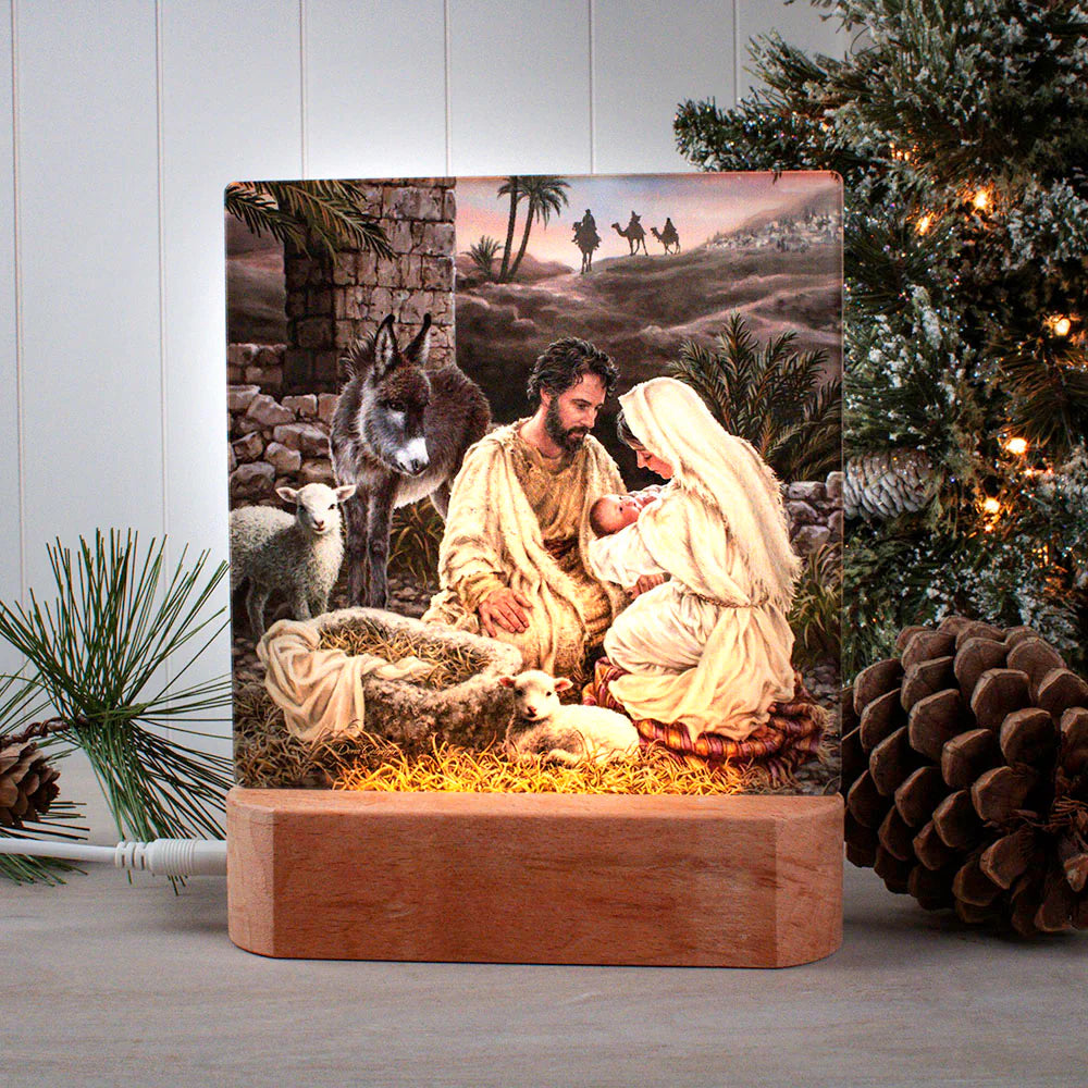Wooden tabletop nightlight plaque depicting Mary, Joseph, and baby Jesus in nativity scene with animals and wise men background