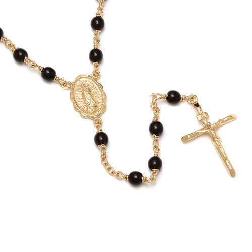 Yellow gold plated rosary necklace with black beads featuring Our Lady of Guadalupe medallion and crucifix pendant on white background